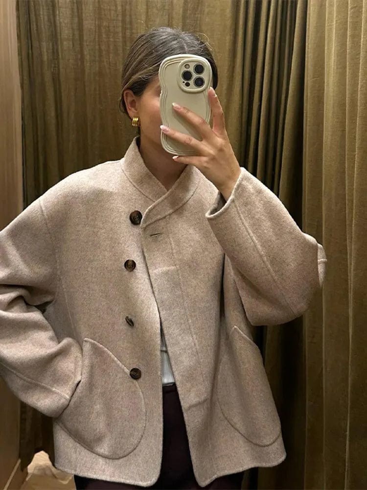 Veste courte pour femme Ethelyn en laine beige, idéale pour l'hiver. Son design épuré avec des boutons en bois et des poches arrondies lui confère un style élégant et pratique. Parfaite pour un look décontracté mais sophistiqué, cette veste vous offrira chaleur et confort lors des journées fraîches.