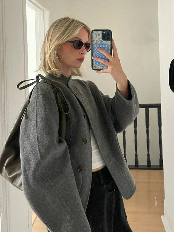 Veste courte pour femme Ethelyn en gris, idéale pour l'hiver. Son design chic et moderne, avec des boutons en bois et une coupe élégante, apporte confort et style. Parfaite pour les journées fraîches, cette veste se marie bien avec un pull chaud et un pantalon fluide, offrant une allure raffinée et décontractée.