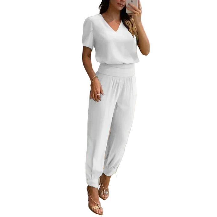Ensemble chic pour femme Eugénie, moderne et élégant, composé d'un haut blanc à col en V et d'un pantalon assorti avec des bords côtelés. Cet ensemble épuré et confortable est parfait pour un look à la fois décontracté et raffiné, idéal pour une tenue de jour ou une sortie.