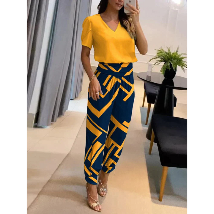 L'ensemble Eugénie pour femme, chic et moderne, se compose d'un haut jaune vif à col V et d'un pantalon à motifs géométriques bleu marine et jaune. Cet ensemble fluide et élégant offre une allure audacieuse et sophistiquée, idéale pour un style dynamique et tendance.