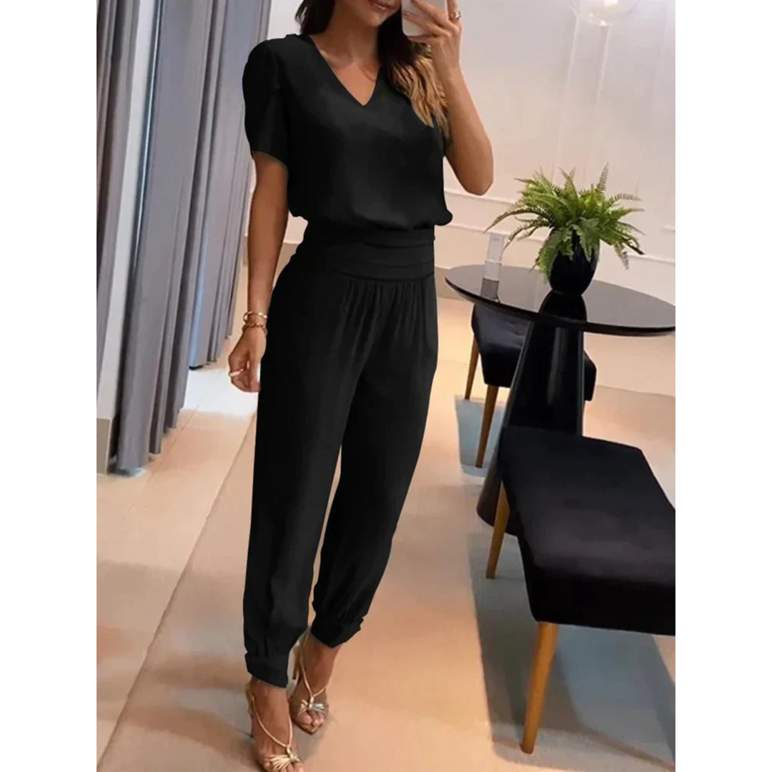 Ensemble chic pour femme Eugénie, moderne et élégant, composé d'un haut noir à col en V et d'un pantalon assorti avec des bords côtelés. Cet ensemble épuré et confortable est idéal pour un look sophistiqué, parfait pour les occasions spéciales ou une sortie élégante.