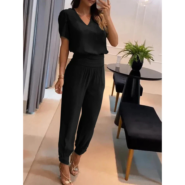Ensemble chic pour femme Eugénie, moderne et élégant, composé d'un haut noir à col en V et d'un pantalon assorti avec des bords côtelés. Cet ensemble épuré et confortable est idéal pour un look sophistiqué, parfait pour les occasions spéciales ou une sortie élégante.
