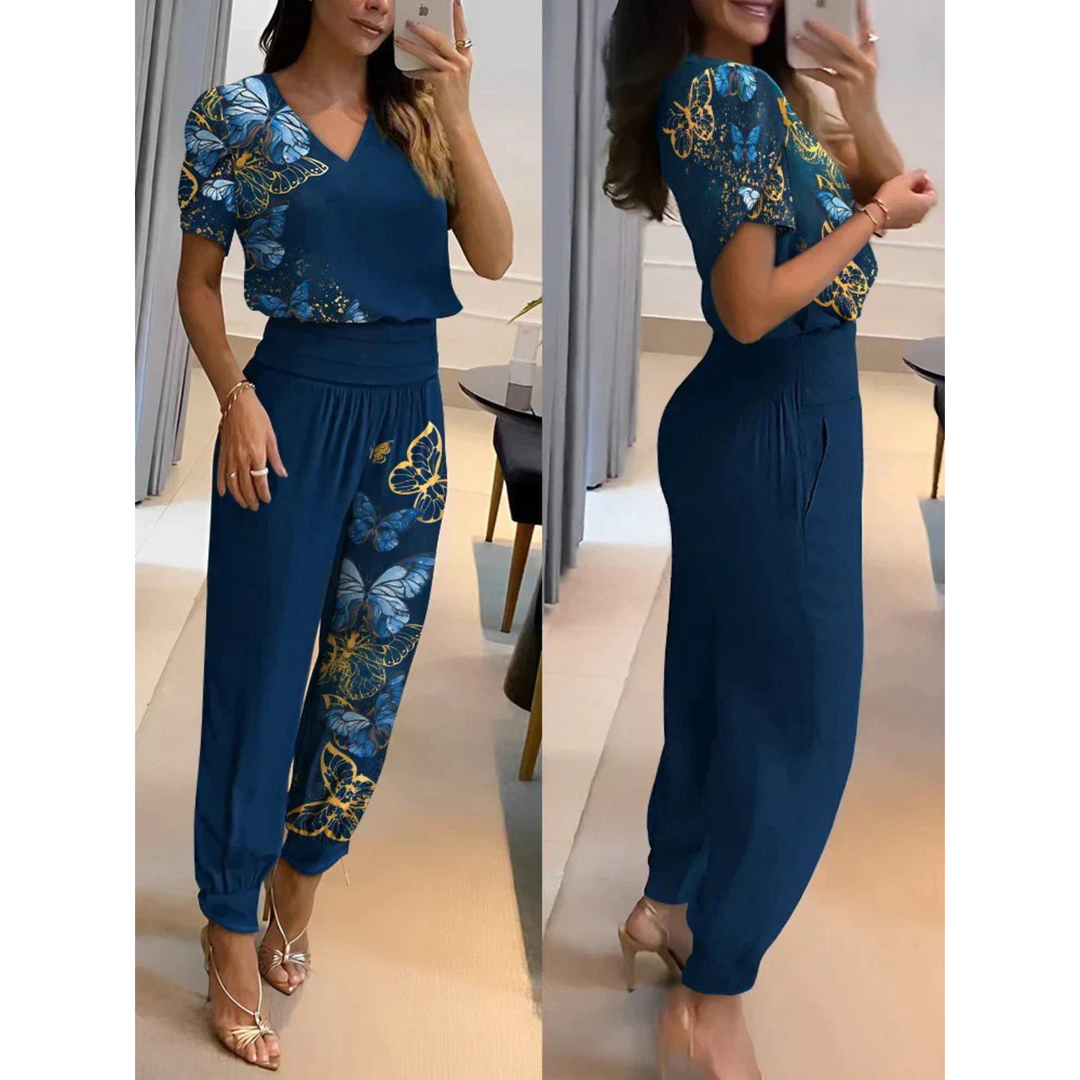 Ensemble chic pour femme Eugénie, moderne et élégant, de couleur bleu avec des motifs de papillons jaunes et bleus. Ce set fluide, comprenant un haut à col en V et un pantalon assorti à bords côtelés, offre un look à la fois raffiné et décontracté, parfait pour un style estival et tendance.