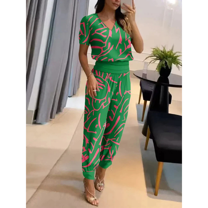 Ensemble chic pour femme Eugénie, moderne et coloré, de couleur verte avec des motifs abstraits roses. Ce set fluide, composé d'un haut à col en V et d'un pantalon assorti, offre un look original et tendance, parfait pour un style estival et dynamique.