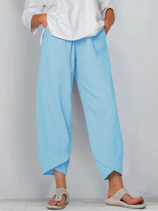 Pantalon palazzo pour femme bleu clair, taille haute et coupe large en tissu léger, avec poches latérales, porté avec une chemise blanche et des sandales pour un style frais, confortable et moderne.