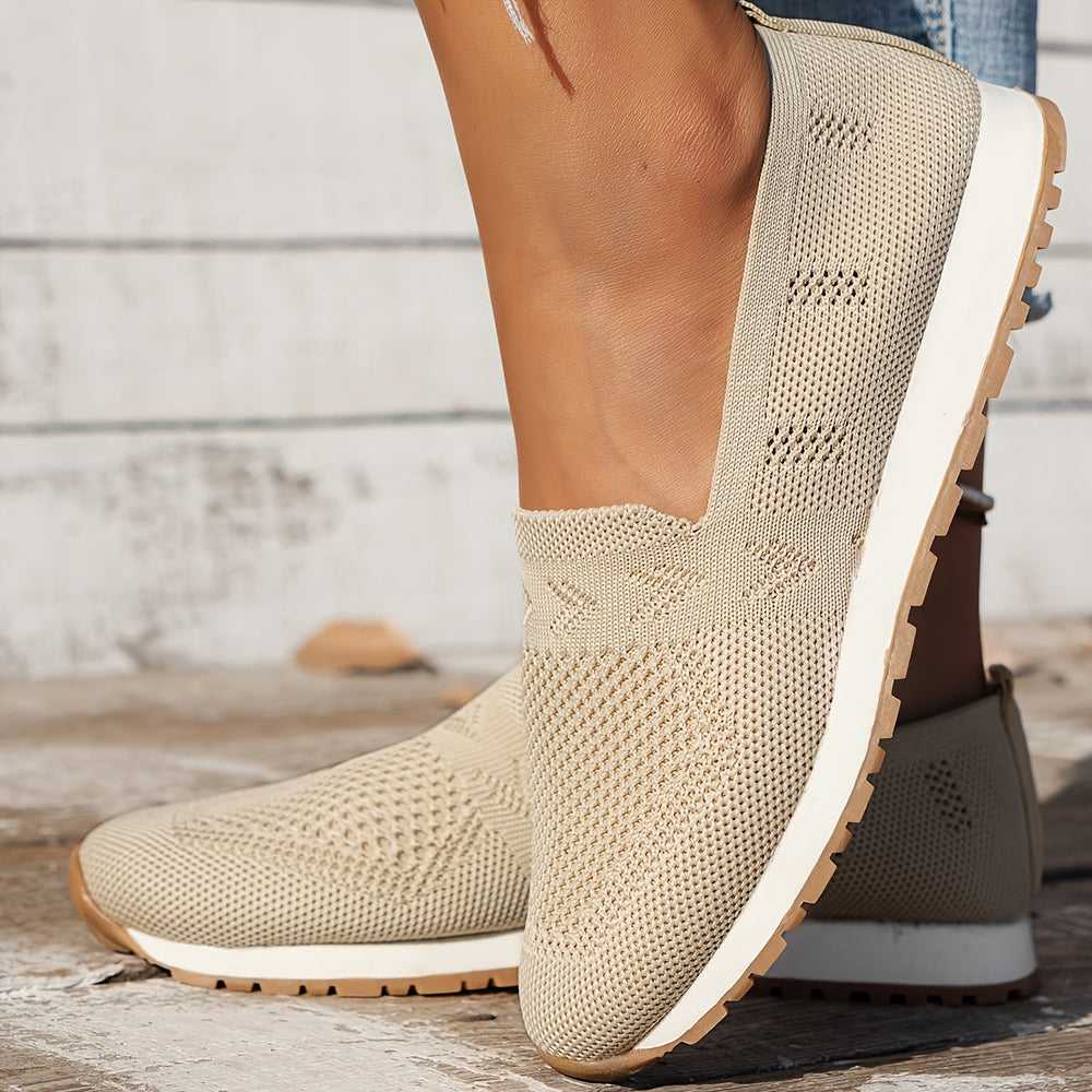 Chaussure d’été femme Fantine tendance en maille respirante beige, modèle slip-on, bout arrondi et semelle épaisse blanche avec dessous cranté, vue de profil portée en extérieur.