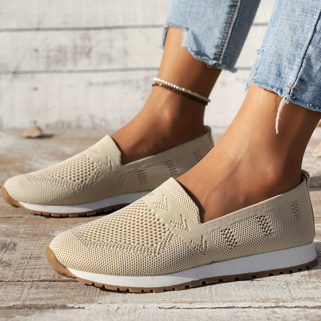 Chaussures d’été femme Fantine tendance portées aux pieds, slip-on en maille beige ajourée, bout arrondi, semelle blanche légère avec dessous cranté, style casual avec jean.
