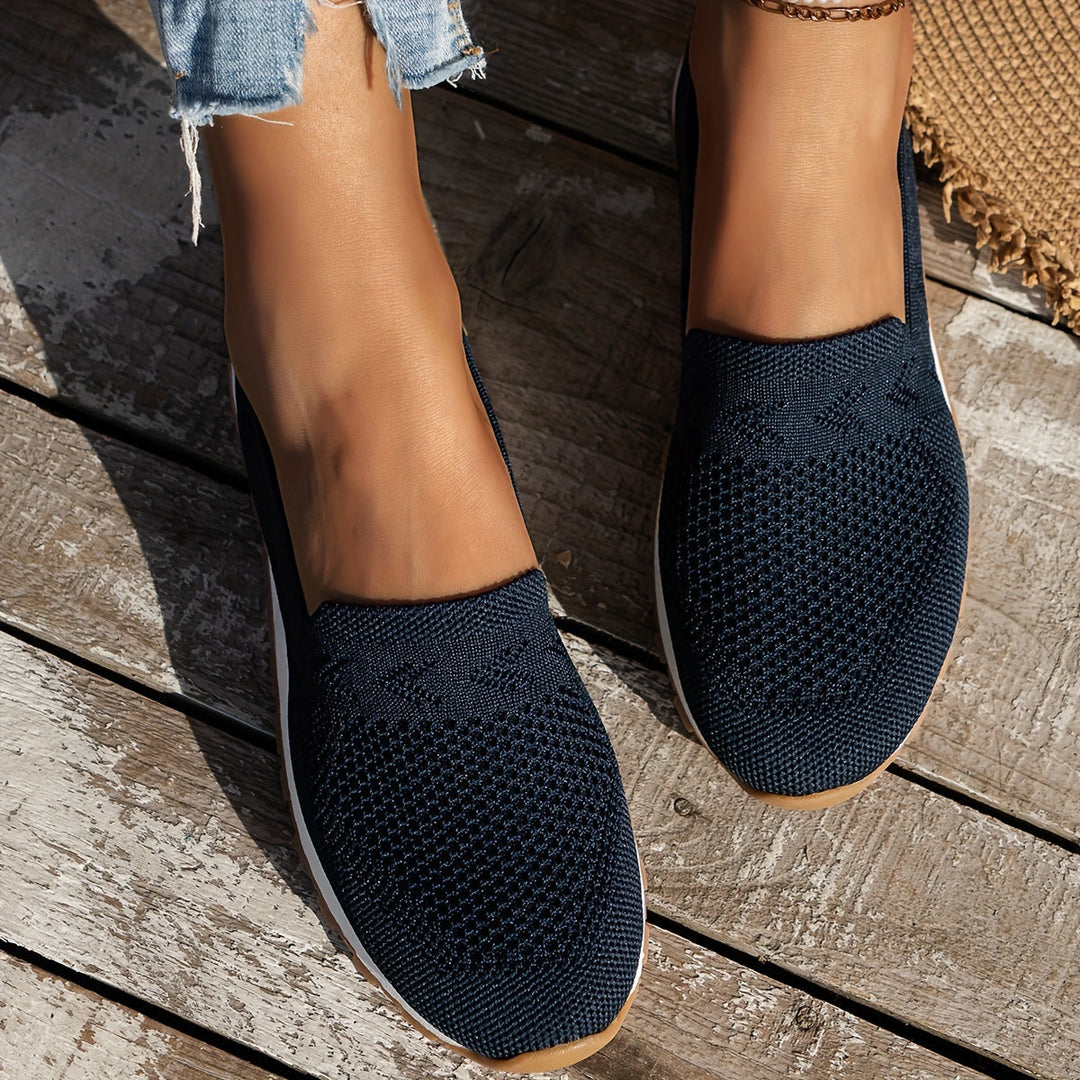 Chaussures d’été femme Fantine tendance bleu marine portées aux pieds, slip-on en maille respirante, bout arrondi et semelle légère, vue de dessus sur terrasse en bois.