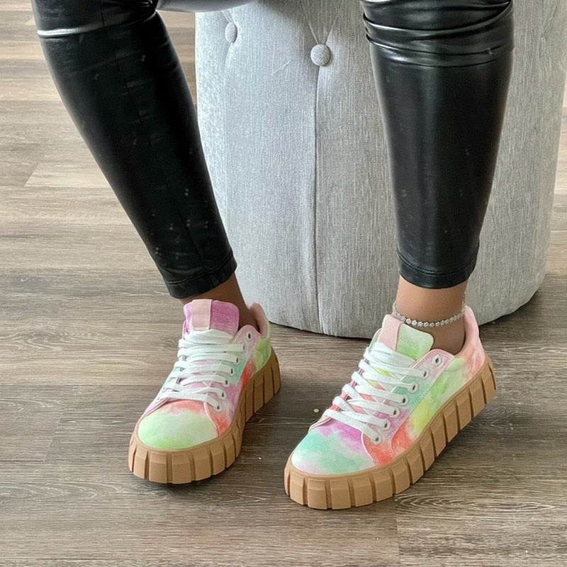 Baskets montantes femme Flavie tendance, sneakers multicolores effet tie-dye rose et vert avec lacets blancs et semelle épaisse beige, portées avec legging noir.