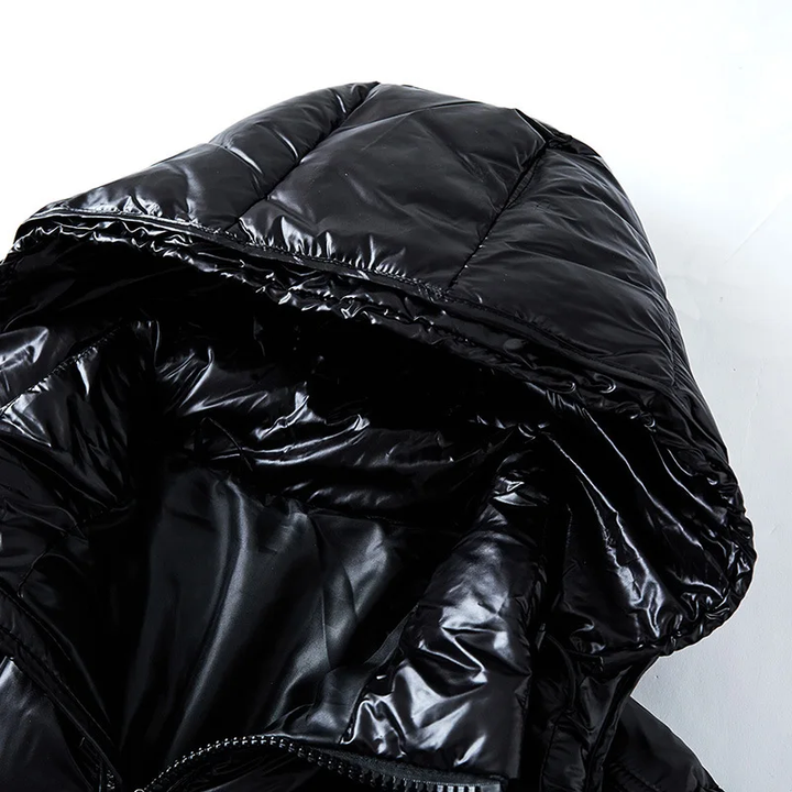 Vue rapprochée de la capuche d'une doudoune noire brillante, montrant l'intérieur matelassé et le tissu lisse. Le design de la capuche est pratique et ajoute une touche moderne à l'ensemble.