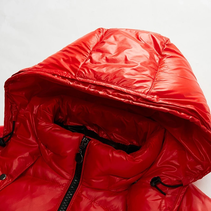 Vue rapprochée de la capuche d'une doudoune rouge brillante, montrant l'intérieur matelassé et les cordons ajustables. Le design de la capuche assure une protection supplémentaire contre le froid.