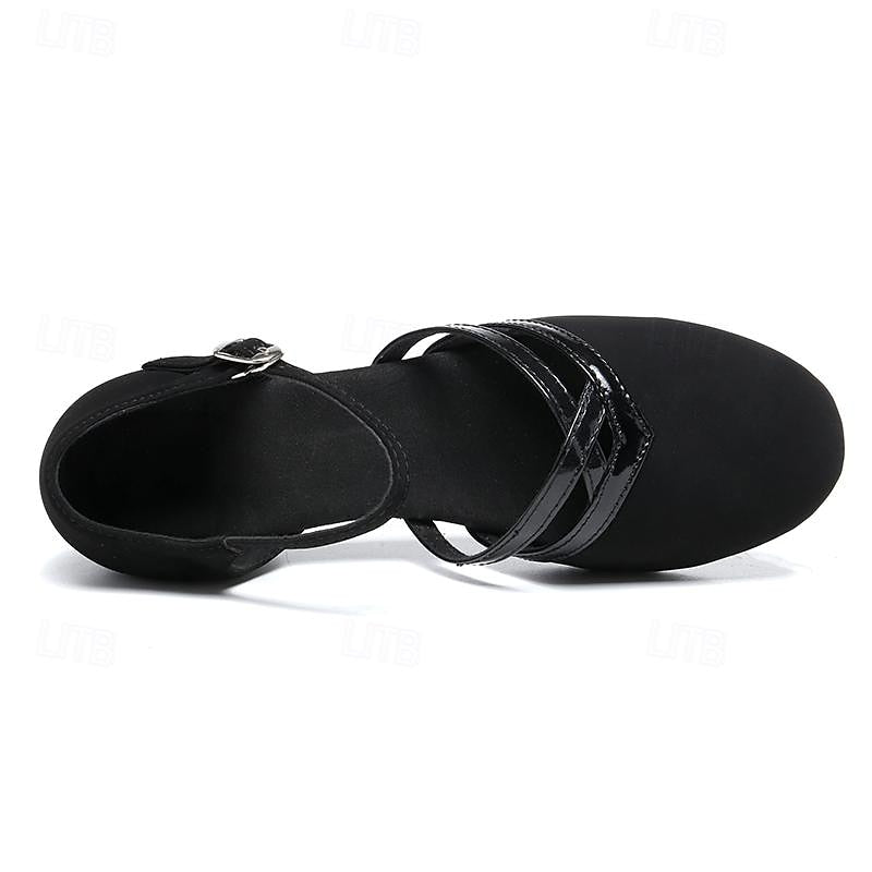 Vue de dessus des chaussures de danse pour femme noires, modèle moderne à bout fermé avec brides croisées vernies et sangle cheville à boucle, sur fond blanc.