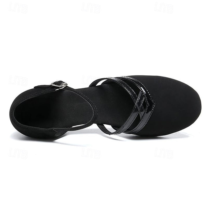 Vue de dessus des chaussures de danse pour femme noires, modèle moderne à bout fermé avec brides croisées vernies et sangle cheville à boucle, sur fond blanc.