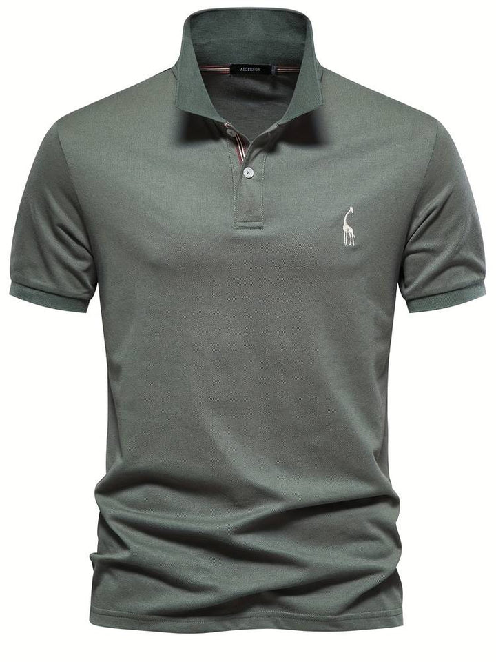 Un polo vert olive avec un petit logo de girafe brodé sur la poitrine. Ce modèle élégant présente un col classique avec des boutons contrastés et des rayures discrètes à l'intérieur, parfait pour un look décontracté et moderne.