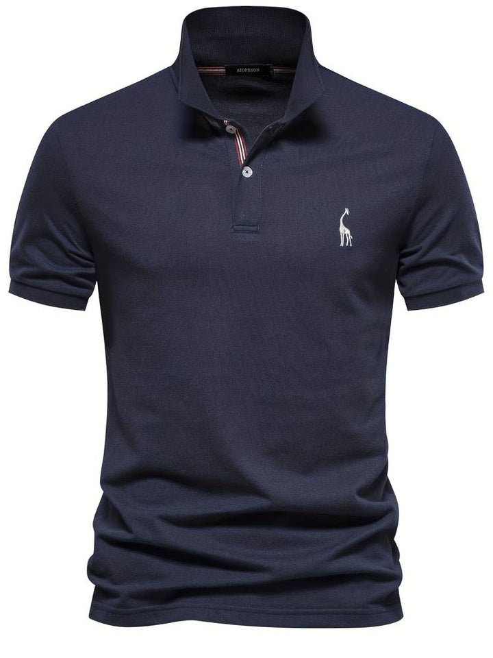 Un polo bleu marine avec un logo de girafe brodé sur la poitrine. Ce modèle élégant dispose d'un col classique avec des rayures discrètes et des boutons contrastés, parfait pour un look moderne et décontracté.
