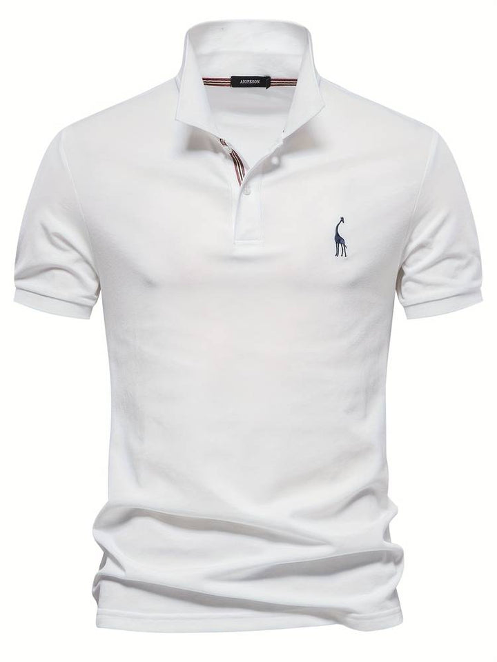 Un polo blanc élégant avec un logo de girafe brodé sur la poitrine. Le col classique avec des rayures discrètes et les boutons contrastés ajoutent une touche moderne et stylée, parfait pour un look décontracté et raffiné.