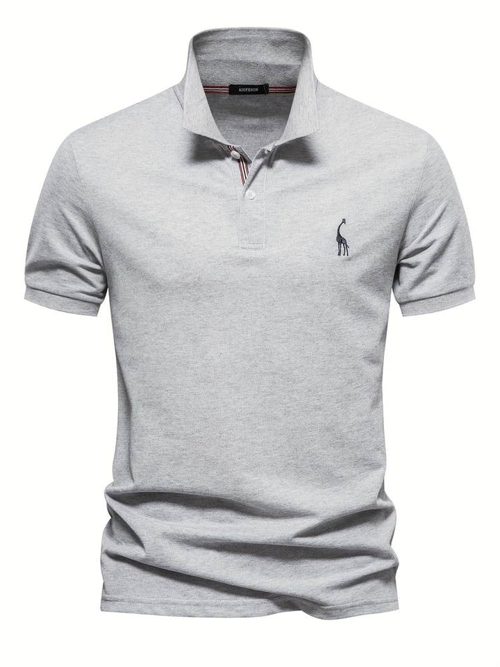 Un polo gris clair avec un logo de girafe brodé sur la poitrine. Ce modèle classique et élégant possède un col avec des rayures discrètes et des boutons contrastés, idéal pour un look moderne et décontracté.