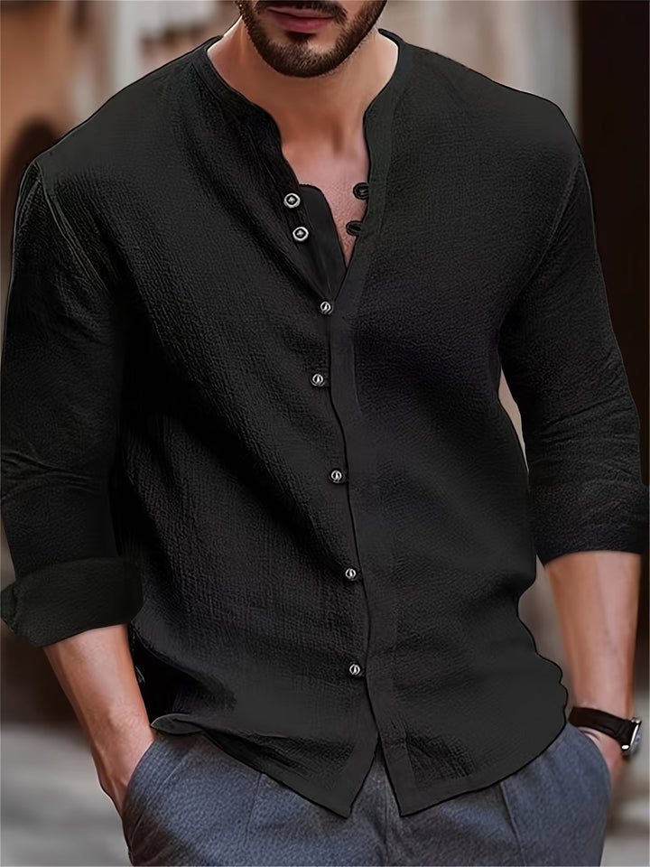 Homme portant la chemise Georges tendance pour hommes, chemise boutonnée noire à manches retroussées, col fendu et coupe moderne, parfaite pour un style casual chic.