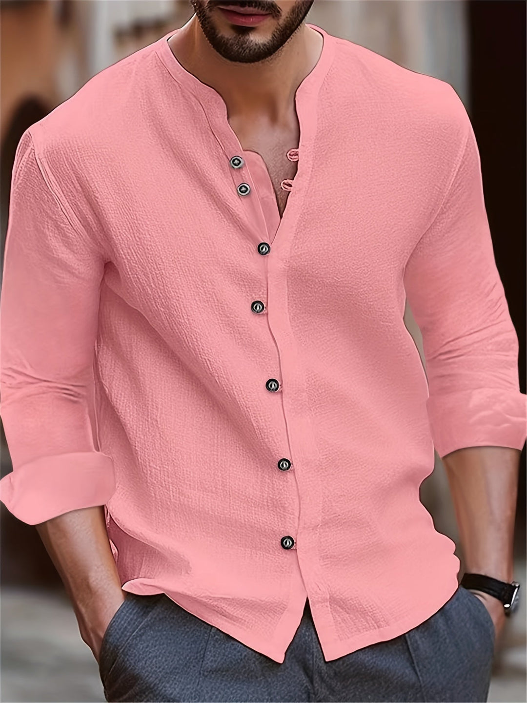 Homme portant la chemise Georges tendance pour hommes, chemise boutonnée rose à manches retroussées, col fendu et coupe moderne, idéale pour un look chic et décontracté.