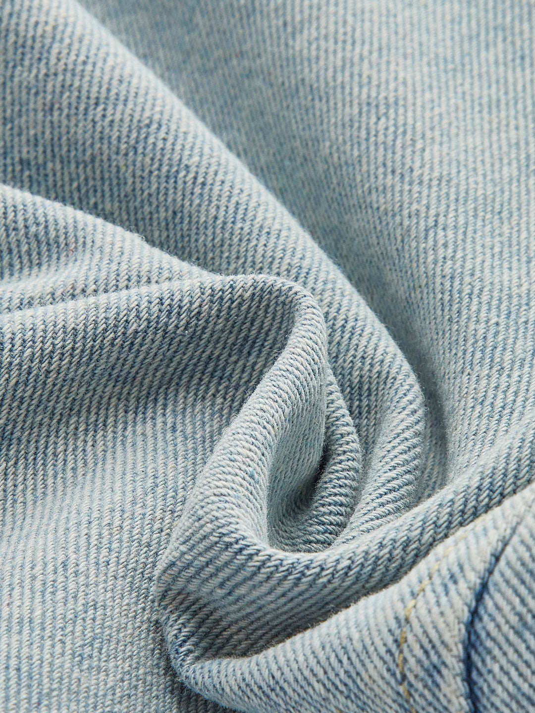 Zoom sur le tissu en denim bleu clair, mettant en avant la texture douce et résistante de cette veste. Ce tissu de qualité assure un confort optimal tout en apportant une touche moderne à vos tenues hivernales.
