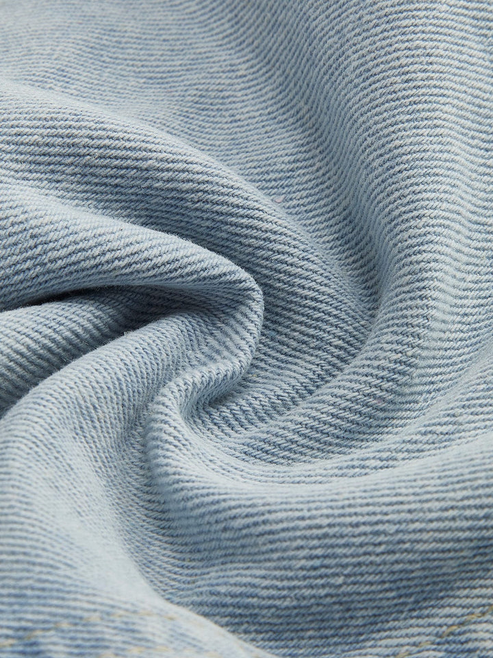 Zoom sur le tissu en denim bleu clair de la veste en jean courte Giselle. Ce denim de qualité, doux au toucher et légèrement texturé, offre une finition soignée. Il est idéal pour une coupe moderne et décontractée, apportant confort et style à votre tenue.