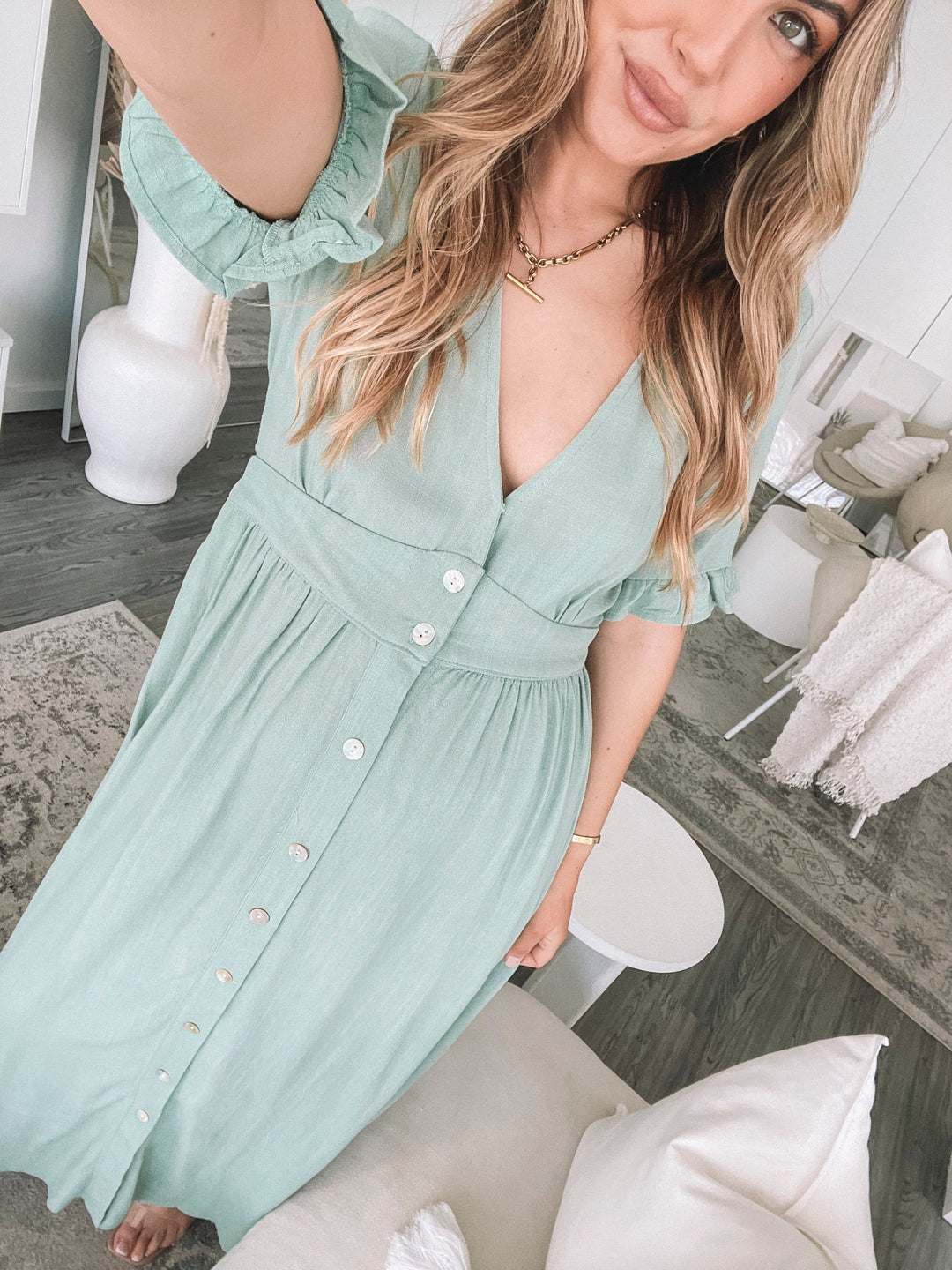 Robe midi d'été pour femme, vue portée par un modèle avec des manches à volants et des boutons sur le devant. Design élégant et léger, parfait pour un look estival chic et confortable.