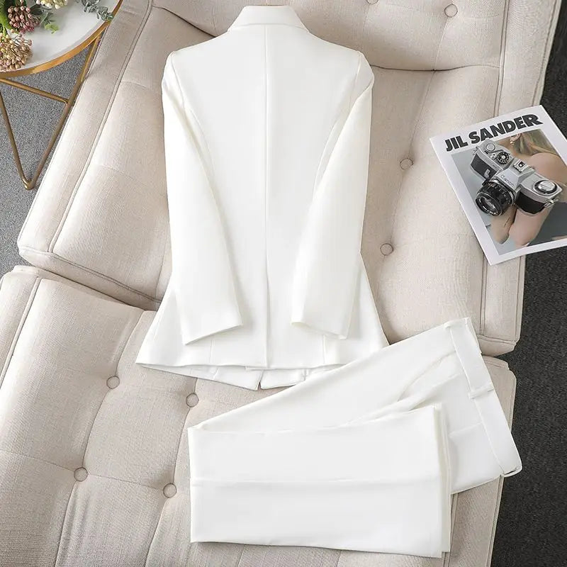Vue arrière du blazer élégant Imane pour femme, un modèle moderne et tendance. Ce blazer blanc, accompagné de son pantalon assorti, offre une coupe élégante et ajustée. Parfait pour un look chic et professionnel, il se distingue par ses finitions soignées et son design minimaliste.