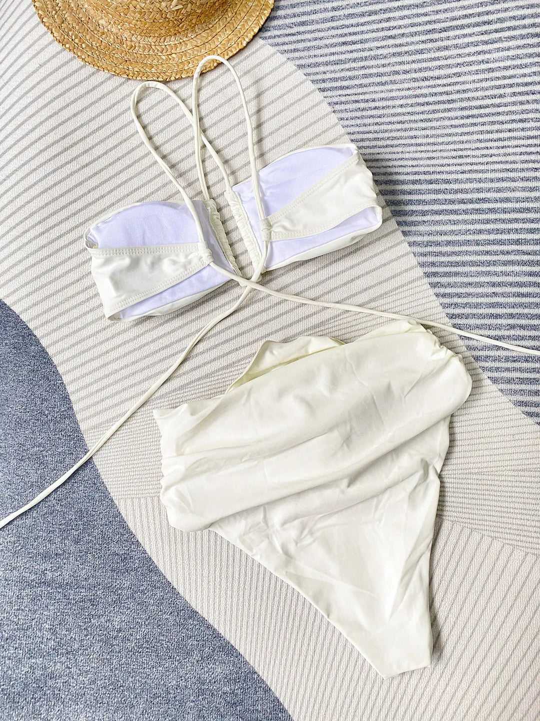 Bikini femme beige vu de dos, avec haut bandeau à fines lanières croisées et culotte taille haute froncée, pour un style tendance et élégant.
