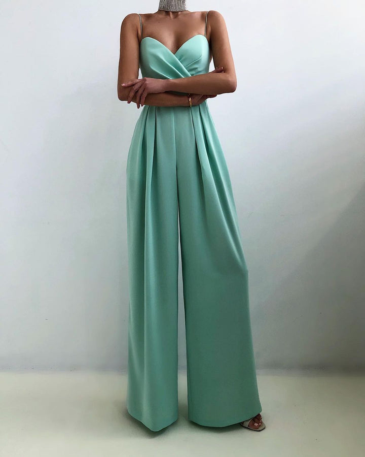 Une combinaison sans manches de couleur menthe avec un décolleté croisé et un pantalon large, créant un look moderne et raffiné.