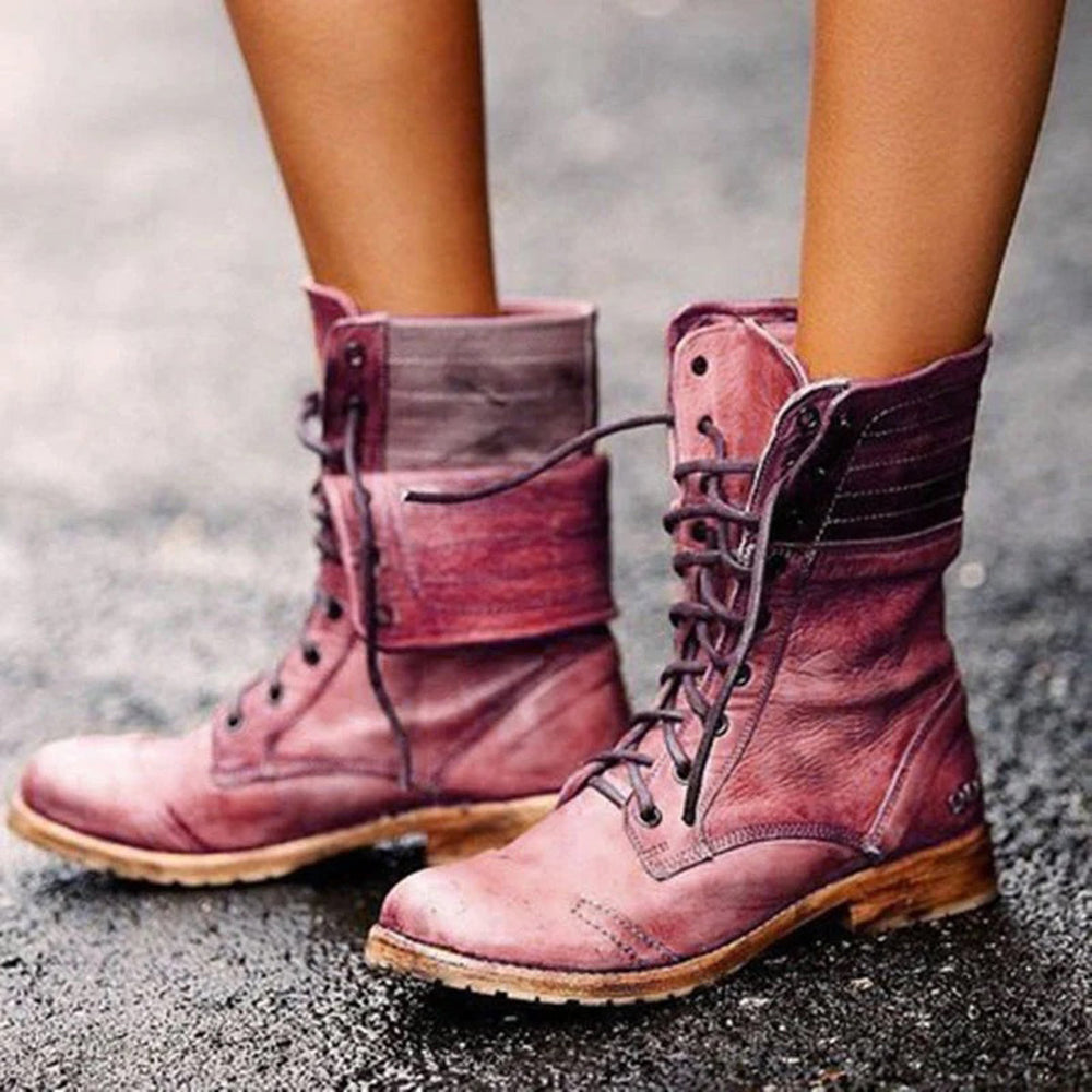 Bottes à lacets pour femme en cuir souple de couleur prune, affichant un style vintage avec une finition légèrement usée. Le design montante offre un look robuste et élégant, idéal pour les saisons froides. La semelle épaisse en caoutchouc naturel ajoute confort et stabilité sur différentes surfaces.
