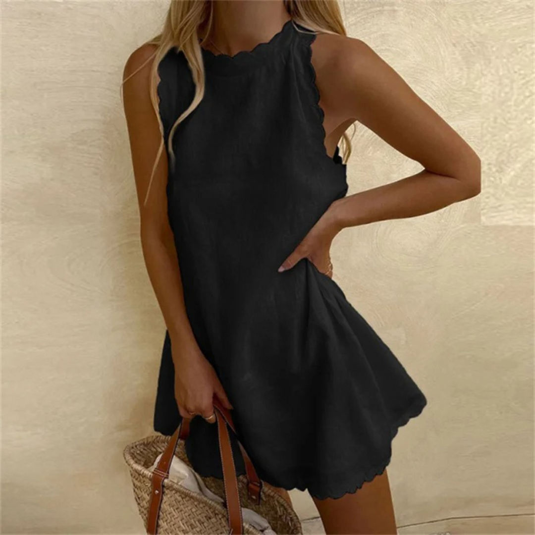 Et légère, cette robe noire à col échancré et bords scallopés est parfaite pour un look estival décontracté, idéale à associer avec un panier en osier.