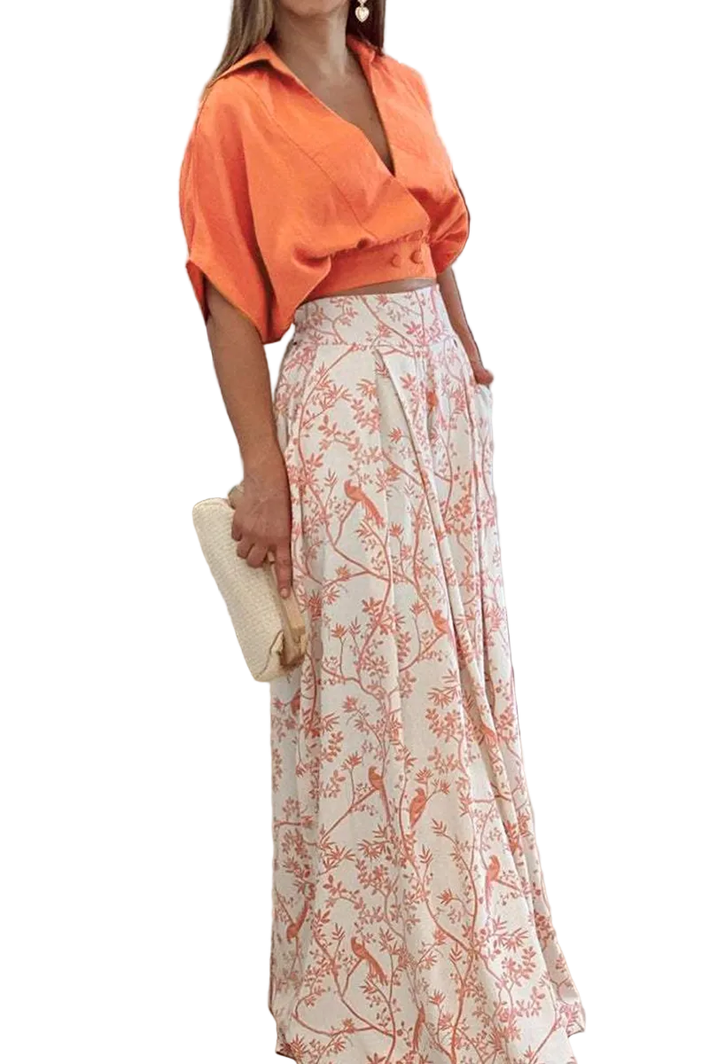 Set pour femme Kaïna, élégant et moderne, composé d'un haut court orange et d'une jupe longue à imprimé floral, parfait pour une occasion estivale chic et raffinée.