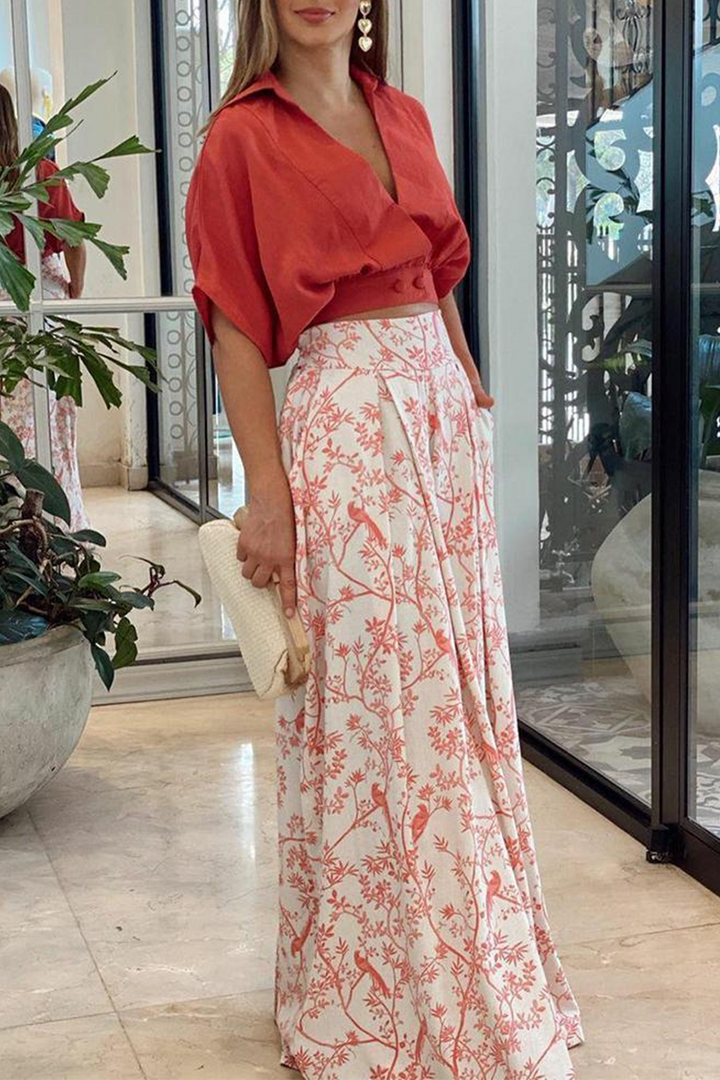Set Kaïna pour femme élégant, comprenant un haut court rouge à manches bouffantes et un pantalon long à imprimé floral rouge et blanc, parfait pour une tenue moderne et sophistiquée.