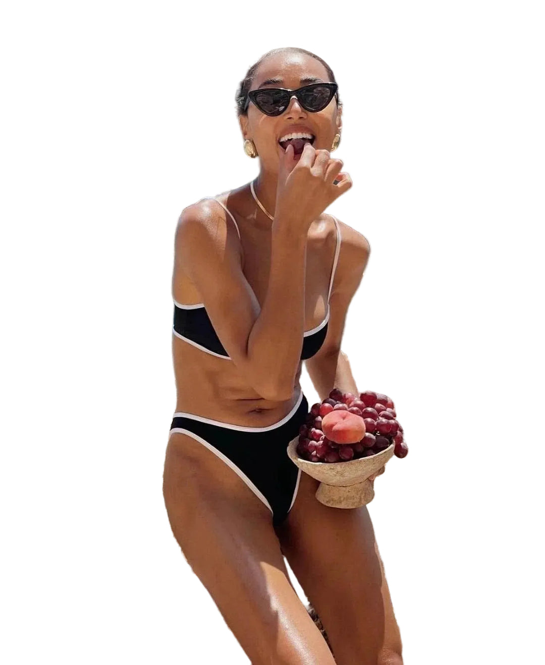 Bikini moderne pour femme Katie ensemble deux pièces noir à bordures contrastées, avec haut à fines bretelles et bas échancré, porté en bord de mer pour un look estival chic et ensoleillé.