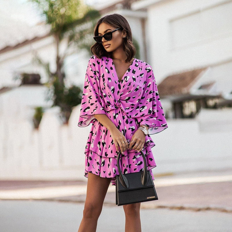 Robe mini florale pour femme de couleur rose avec un motif abstrait noir, à manches courtes et volants, idéale pour un look moderne et élégant lors des sorties estivales.