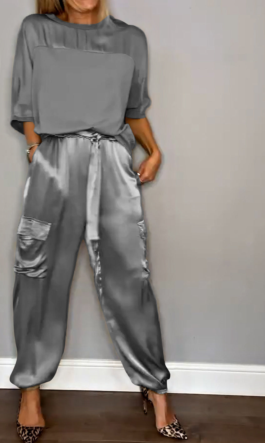 Une tenue chic composée d'un haut gris satinée et d'un pantalon fluide à taille élastique avec des poches, porté avec des escarpins à motif léopard.