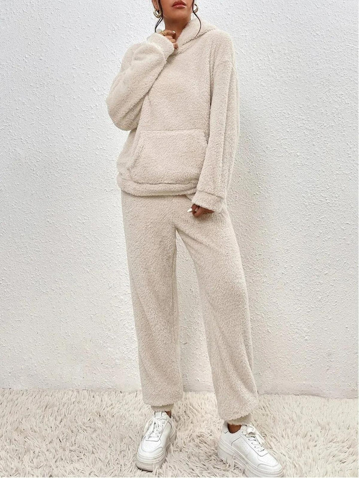 Ensemble loungewear beige en tissu doux et duveteux pour femme, composé d’un sweat à capuche ample et d’un pantalon confortable assorti, offrant un style cosy et moderne.