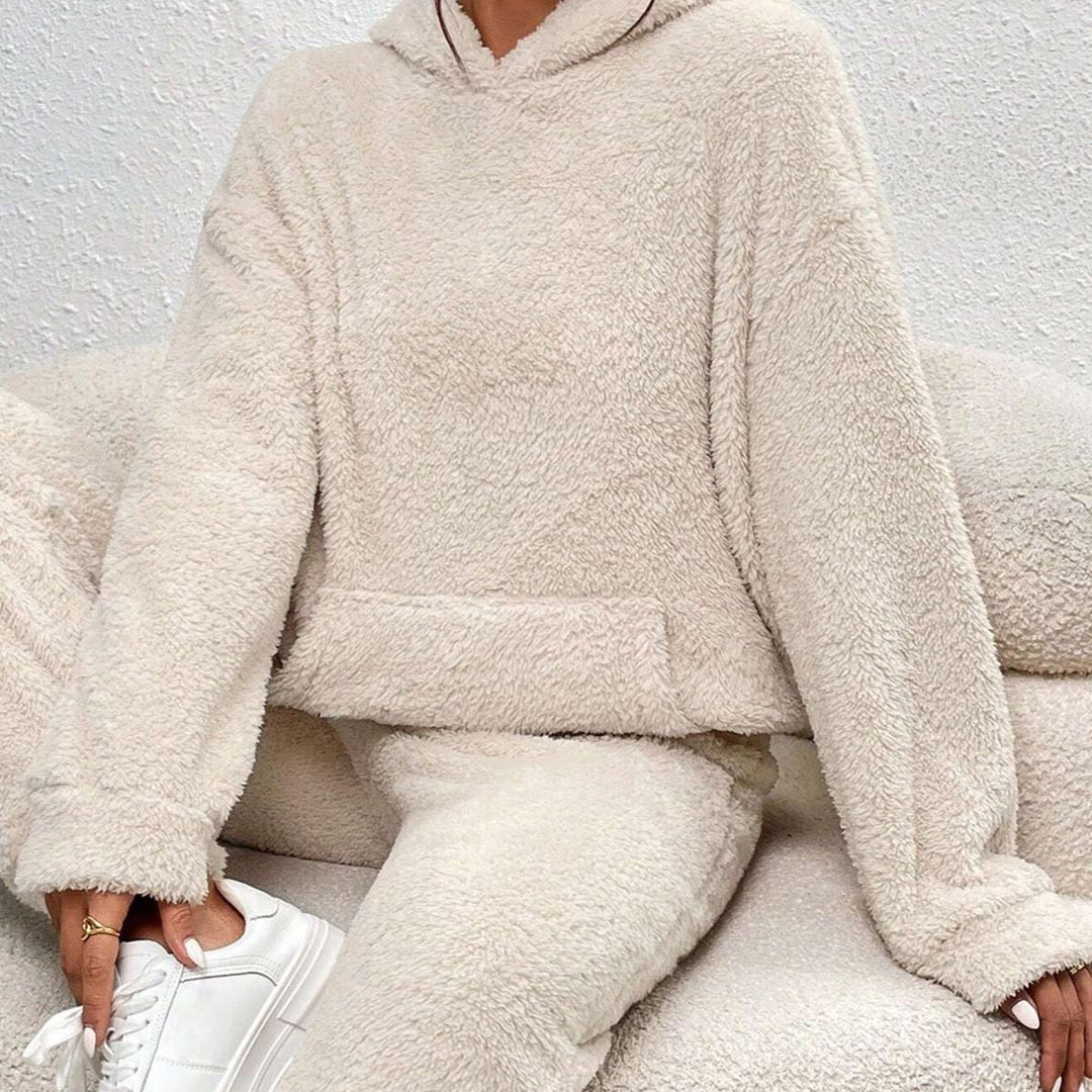 Ensemble loungewear douillet pour femme, composé d’un hoodie et d’un pantalon assorti en tissu teddy beige, offrant une allure cosy et moderne pour les moments de détente.