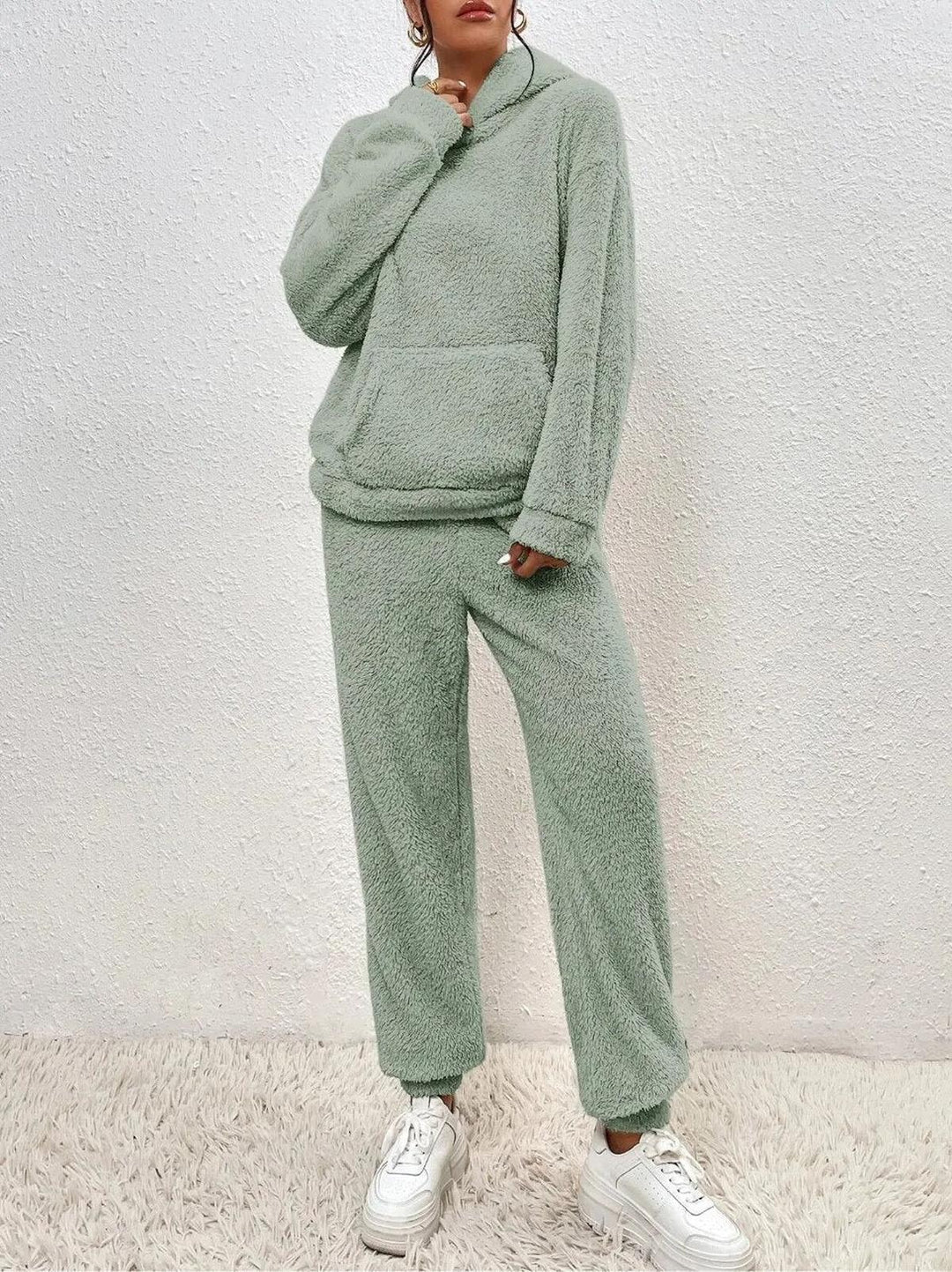 Ensemble loungewear en tissu teddy vert clair pour femme, composé d’un hoodie ample et d’un pantalon confortable, offrant un look doux et cocooning idéal pour la détente à la maison.
