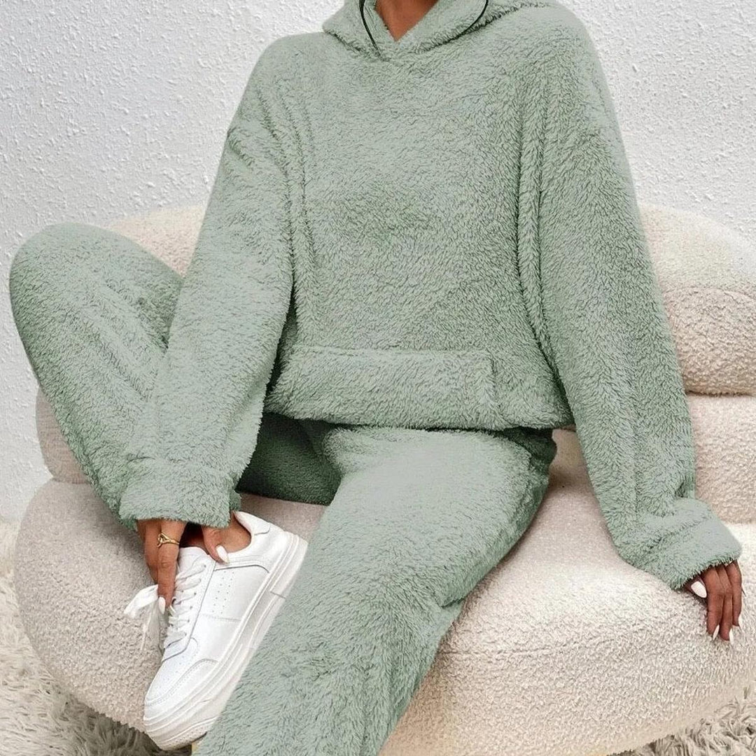 Ensemble loungewear pour femme en tissu teddy vert clair, composé d’un hoodie ample et d’un pantalon confortable, offrant un style cosy idéal pour les moments de détente.