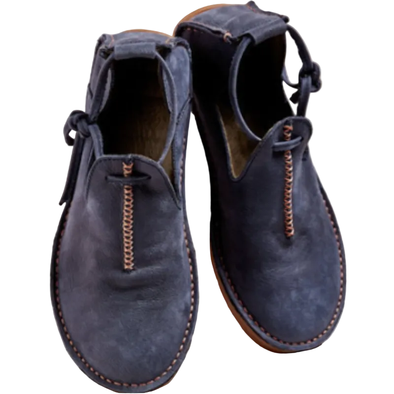 Chaussures d’automne pour femme en cuir suédé bleu foncé, avec bout arrondi, coutures contrastantes apparentes et lien décoratif à l’arrière, posées sur un fond clair pour mettre en valeur leur style moderne et élégant.