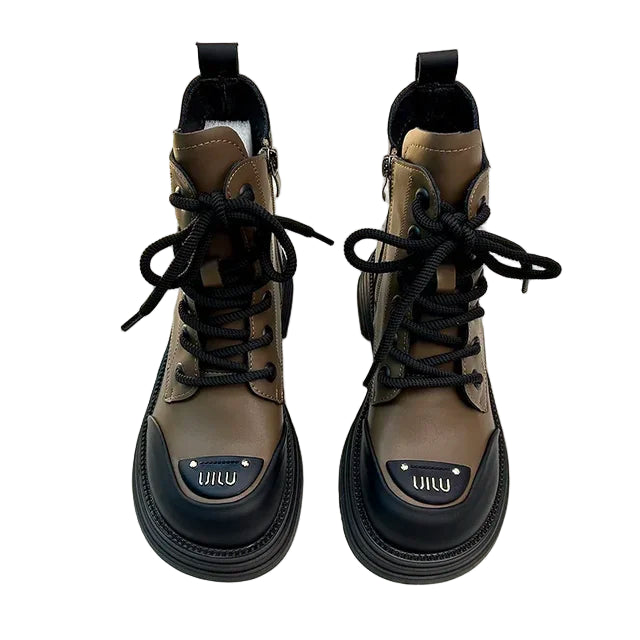 Chaussures de femme élégantes avec une finition robuste, présentant des bottines marron avec des lacets noirs. Le design inclut une partie avant noire et une semelle épaisse, créant une silhouette tendance et moderne idéale pour l'automne et l'hiver.