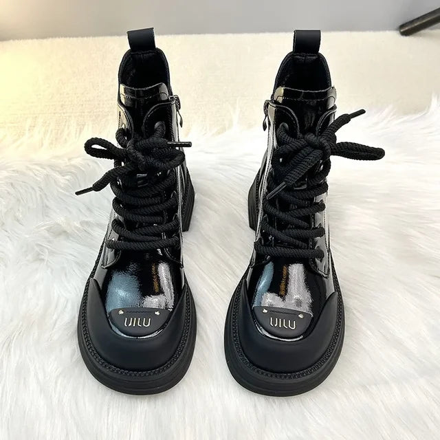 Bottines noires brillantes pour femme avec des lacets noirs, présentant une semelle épaisse et un design moderne avec une touche de brillance, parfaites pour un look tendance et audacieux.