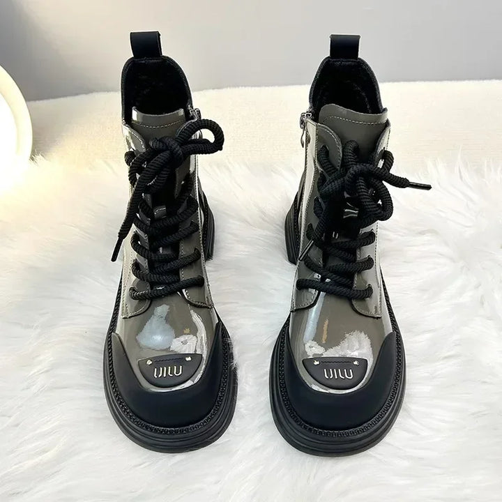 Bottines pour femmes en cuir noir avec lacets, semelle épaisse et zip latéral, offrant un style moderne et robuste.