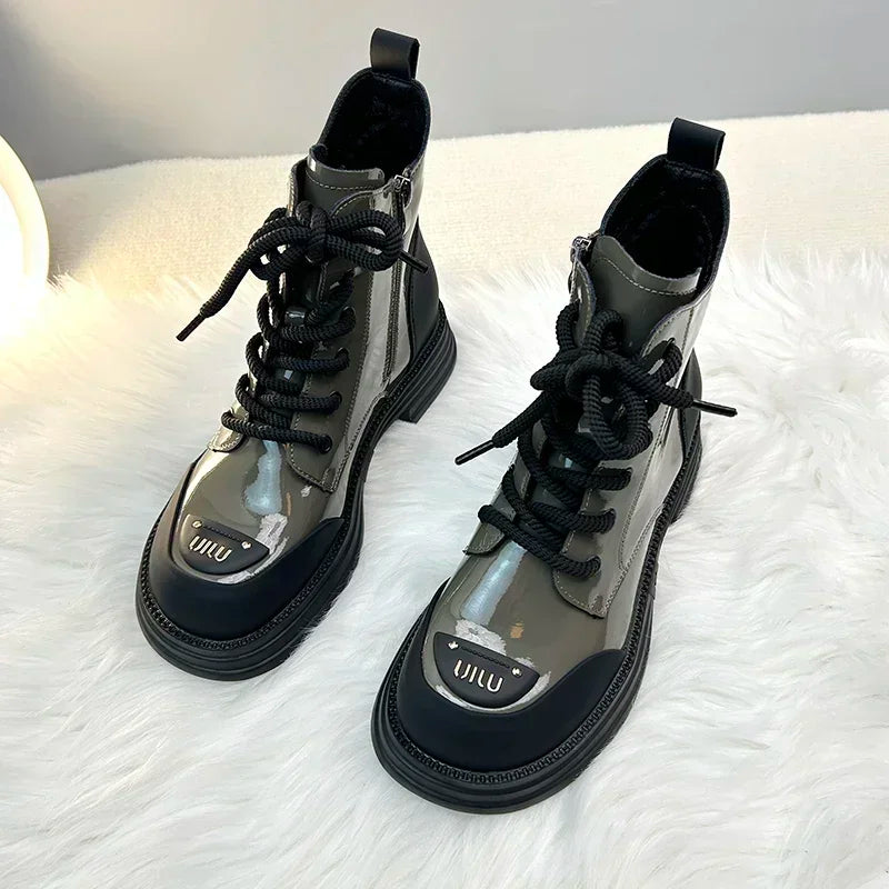 Vue de face de bottines pour femmes avec un design moderne, en cuir brillant et une semelle noire robuste, offrant à la fois confort et style.