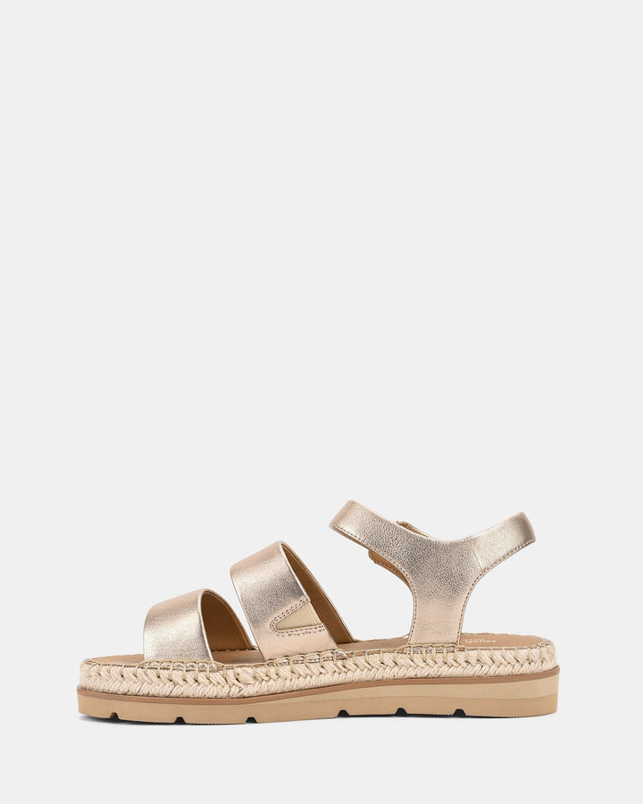 Sandales modernes avec des lanières dorées et une semelle tressée, offrant confort et style pour l'été.