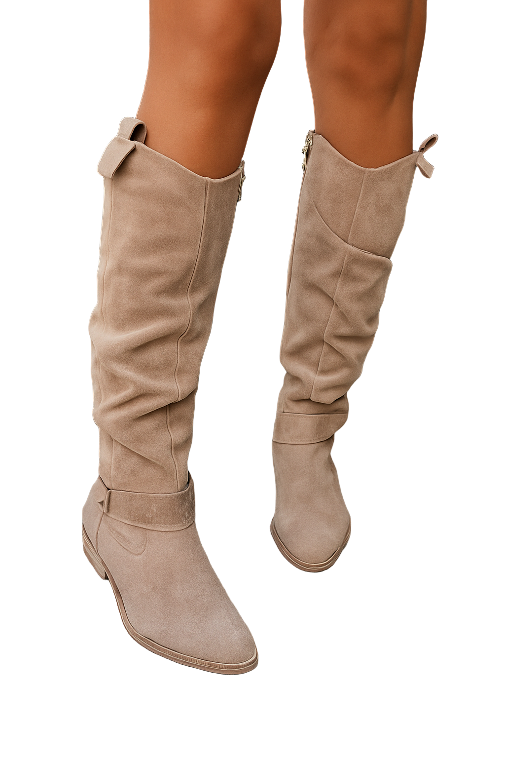 Gros plan sur des jambes de femme portant des bottes montantes en daim beige, posée sur des marches en pierre. Les bottes présentent un design moderne avec une tige souple, un petit talon et une bride décorative, offrant un style élégant et contemporain.