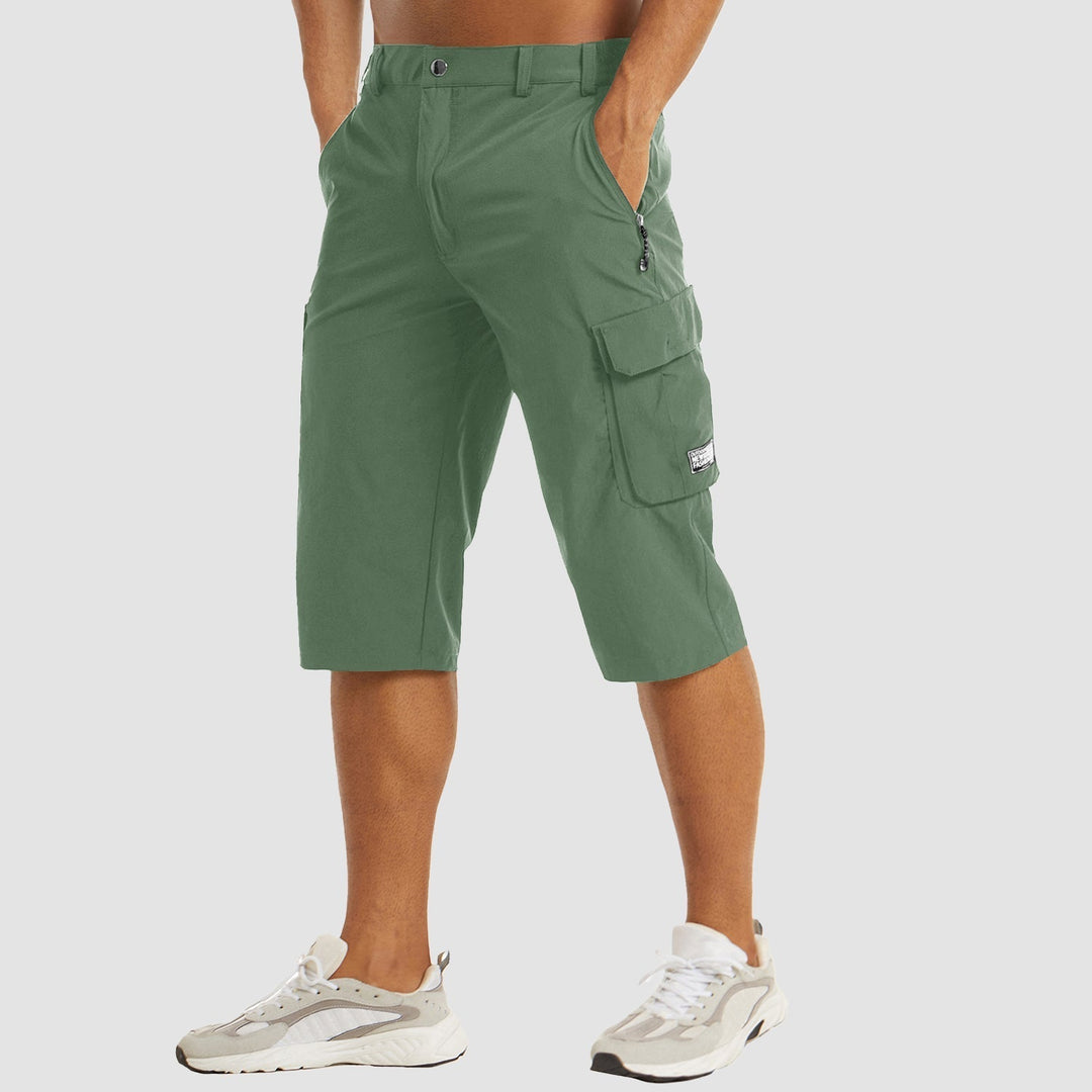 Short cargo homme vert avec coupe longueur genou, poches latérales à rabat, fermeture zippée et passants de ceinture, look tendance et pratique.