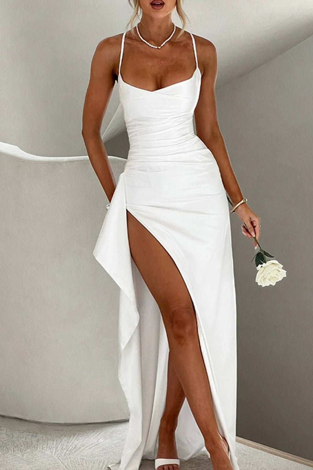 Robe maxi satinée blanche avec une coupe ajustée et une fente haute qui ajoute une touche de sensualité. Parfaite pour une soirée ou une fête, cette robe élégante et chic met en valeur la silhouette tout en offrant confort et raffinement grâce à son tissu fluide et son design sophistiqué. Un choix idéal pour un look sexy et glamour.