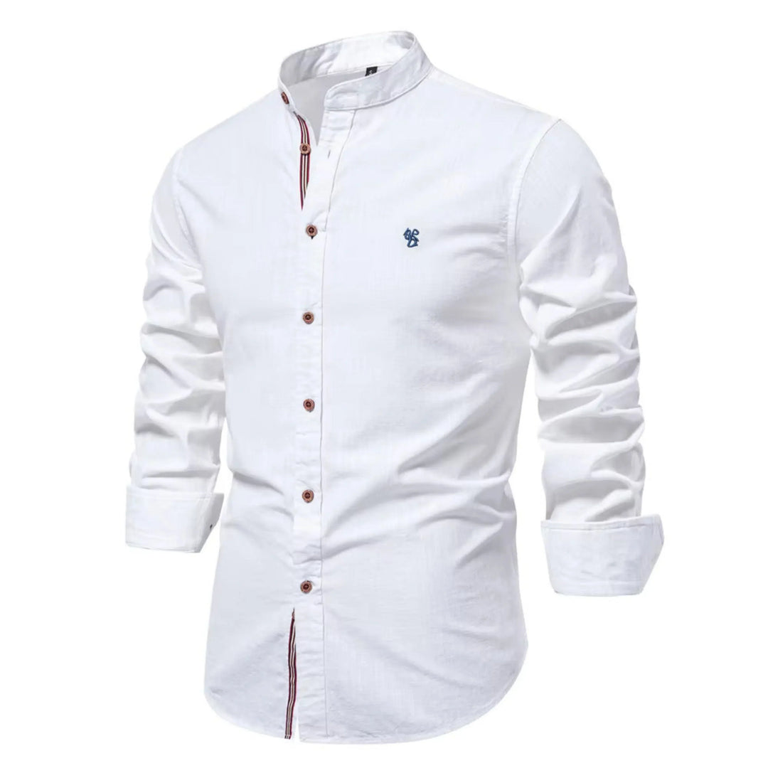 Cette chemise blanche à manches longues présente un col Mao élégant et des boutons en bois contrastés. Elle est ornée d'un petit logo bleu brodé sur la poitrine, offrant un look à la fois raffiné et décontracté, parfait pour les journées fraîches.
